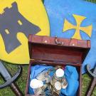 Deux boucliers, deux épées et un coffre rempli de pièce d'or