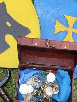 Deux boucliers, deux épées et un coffre rempli de pièce d'or